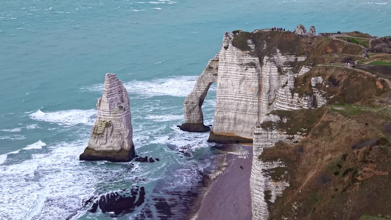 Falaise d'Aval and Aiguille rock formations in Etretat, French coastal landscape, Normandy, France. Aerial drone forward