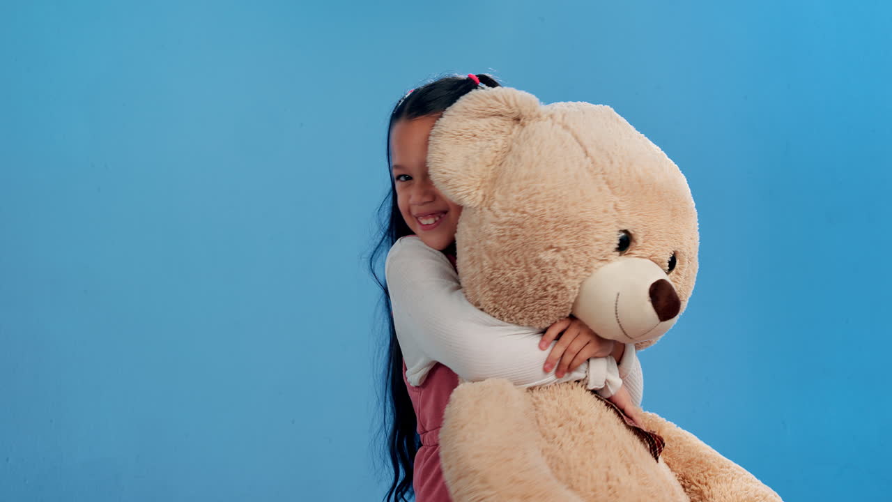 A happy girl hugging a teddy bear