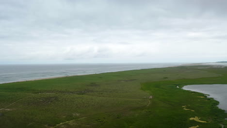 toma aérea de drones del océano y pantanos en un día nublado oscuro en cape cod, massachusetts, panorámica a la derecha