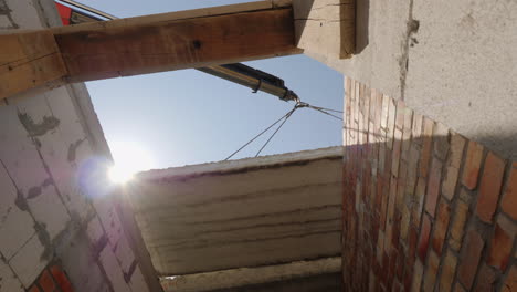 una grúa instala un panel de piso en un edificio de varios pisos una vista inferior
