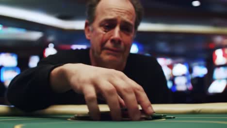 a deeply emotional moment at the casino: a player struggles with the weight of their decisions and the impact of gambling while playing at the table