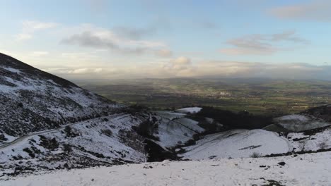 moel famau welsh snowy mountain valley aerial view cold agricultural rural winter landscape orbiting right