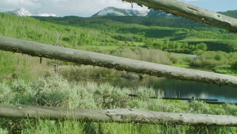 wood fence scenic landscape with forest trees in colorado snow capped mountains