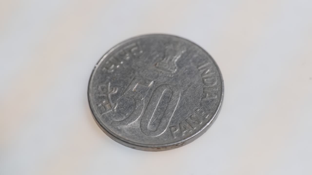 Mid shot of old indian fifty paise coin with indian national emblem. internal shot, parallax shot, 4k.