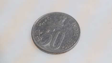 mid shot of old indian fifty paise coin with indian national emblem. internal shot, parallax shot, 4k.