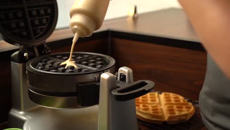 putting adding dough in to gofrera waffle maker oster in slow motion