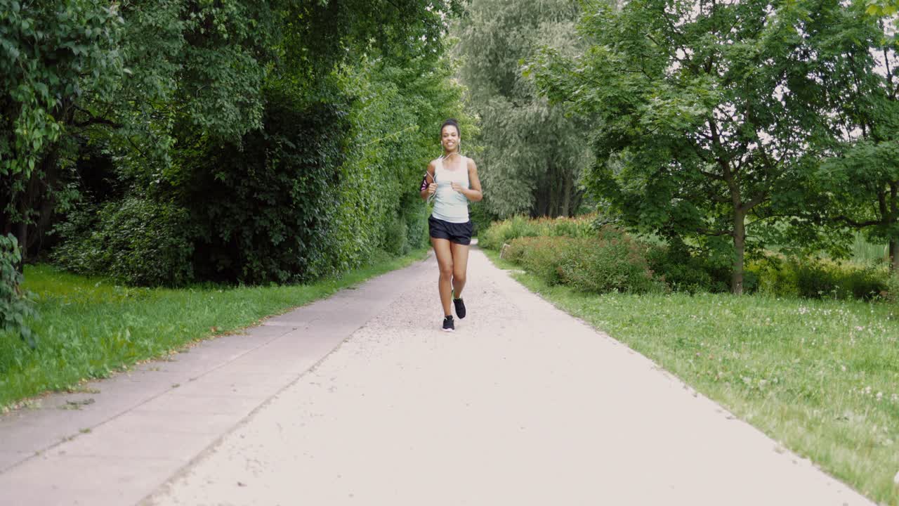 Cheerful woman running in park