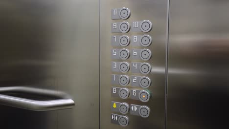 Weibliche-Hand-Drückt-Den-Knopf-Im-Erdgeschoss-In-Einem-Aufzug