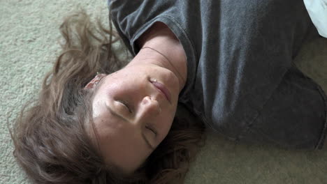 a woman lays on the floor reading a heartfelt, handwritten love letter. the camera transitions from the letter to her face in a slow, smooth movement.