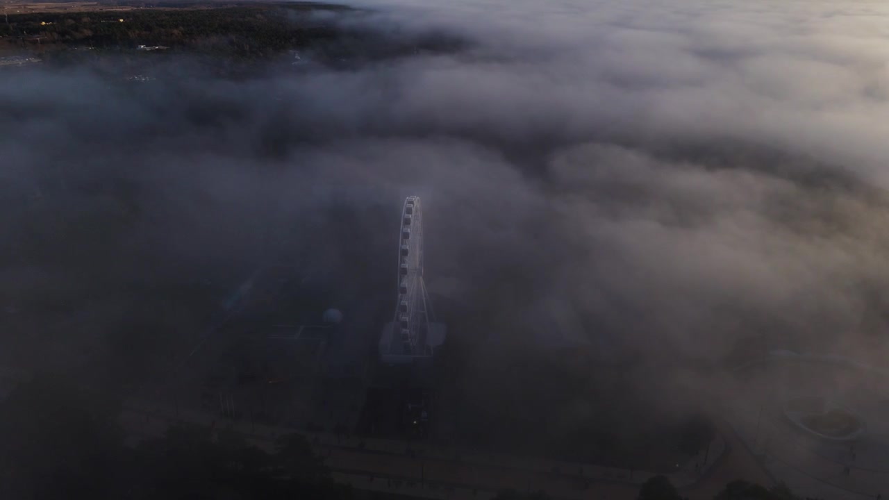 Thick rolling fog illuminated by sunset light, nature atmosphere, elevated view.
