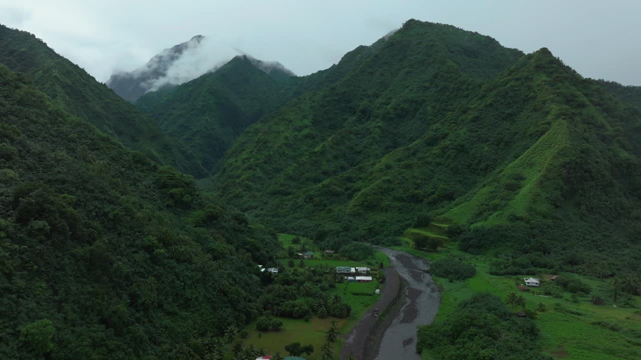 tahití polinesia francesa teahupoo avión no tripulado llueve niebla picos de las montañas río mañana gris temporada gris húmedo punto verde faremahora pueblo ciudad sur del pacífico monte tohivea isla hacia adelante pan up movimiento