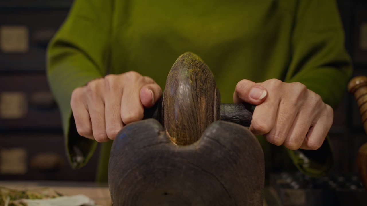 Female Herbalist Using Ancient Roller for Grinding Ingredients