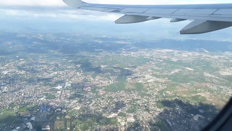 Hoch-In-Einem-Flugzeug-über-Einer-Reihe-Von-Gebäuden-Fliegen