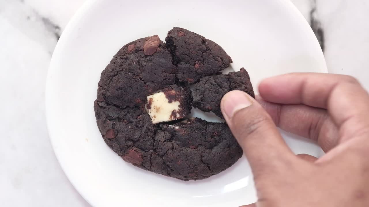 초콜릿 가득 찬 초콜릿  쿠키 한 조각 을 손 으로 뽑는 것