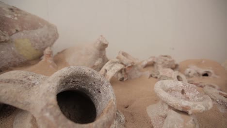 Langsames-Hineinschieben-über-Antike-Töpferwaren,-Die-Teilweise-Im-Sand-Vergraben-Sind