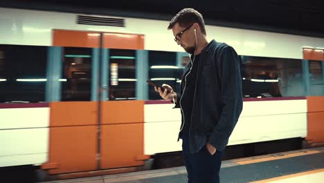 man using smartphone at a train station