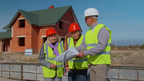 Real-estate-agent-manager-architect-showing-modern-house-to-senior-grandparents-family-client-couple