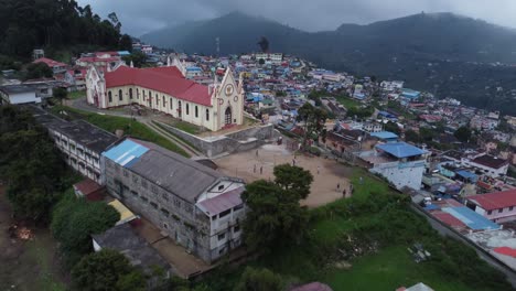 Cinematic-drone-shot-revealing-Sacred-Heart-Catholic-Church-and-Kodaikanal-town-in-the-hills-of-Western-Ghats,-Dindigul,-Tamil-Nadu,-India