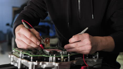 técnico automotriz diagnosticando una placa de circuitos