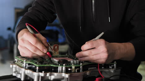 automotive technician diagnosing a circuit board