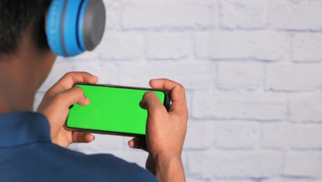 person playing mobile game with green screen