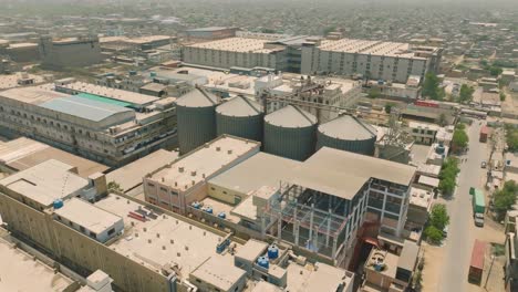 aerial view of karachi's industrial landscape with warehouses and factories under a hazy sky, showcasing the city's manufacturing hub