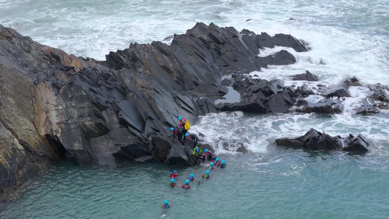 Coasteering Adventure: Group of People Exploring Rocky Coastline