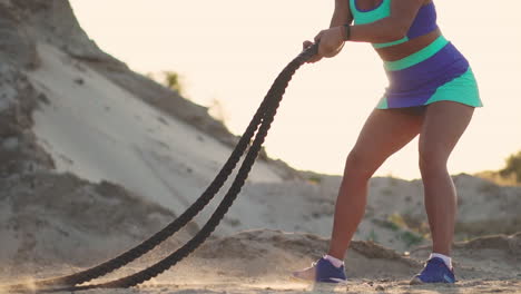 weibliche athletin trainiert im freien um die sandhügel bei sonnenuntergang. aktive körperliche aktivität training. crossfit