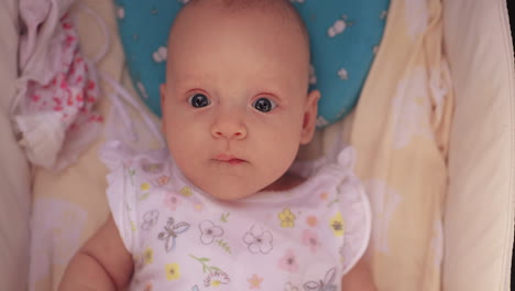 Portrait-of-baby-girl-in-pram-looking-to-the-camera