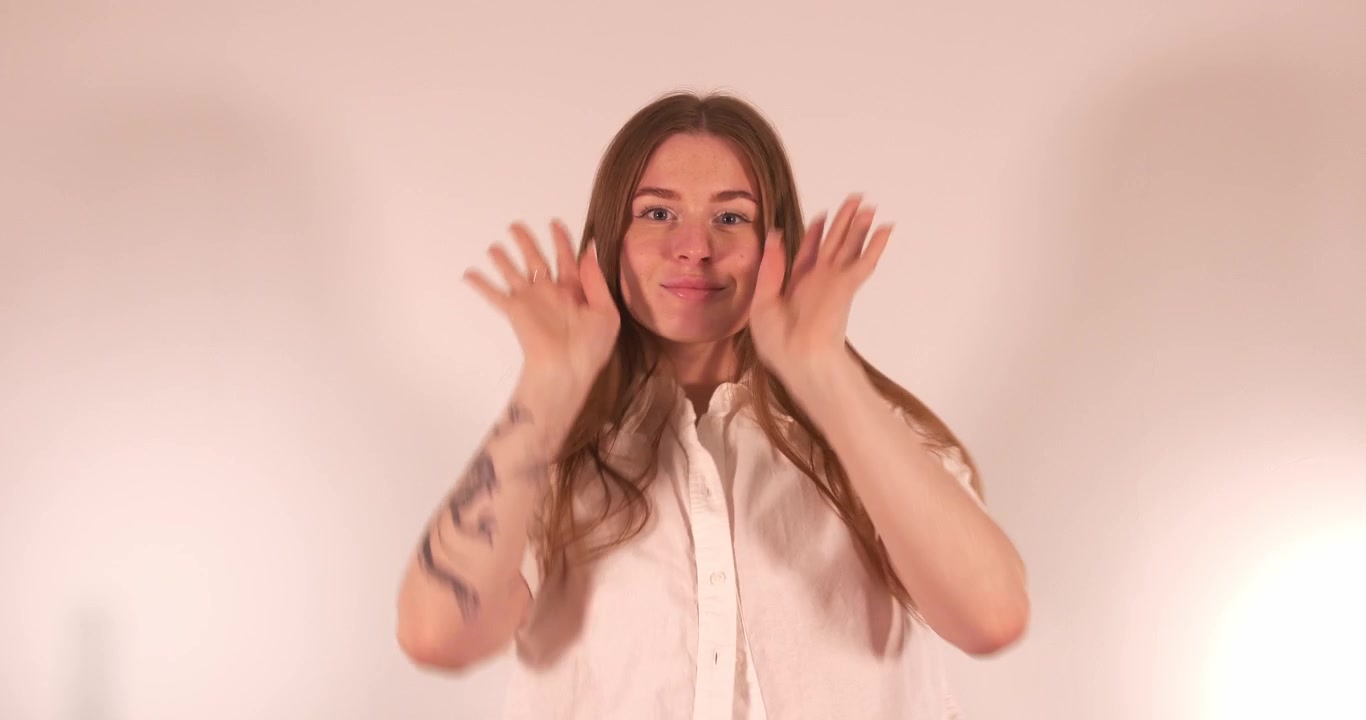 Bella ragazza che balla in modo affascinante mentre si sistema e sorride alla telecamera. Primo piano medio.