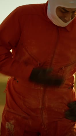 astronauta masculino en traje naranja sacude el polvo de contaminación tóxica de su uniforme