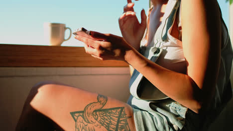 Woman-sitting-near-window-and-using-mobile-phone-4k