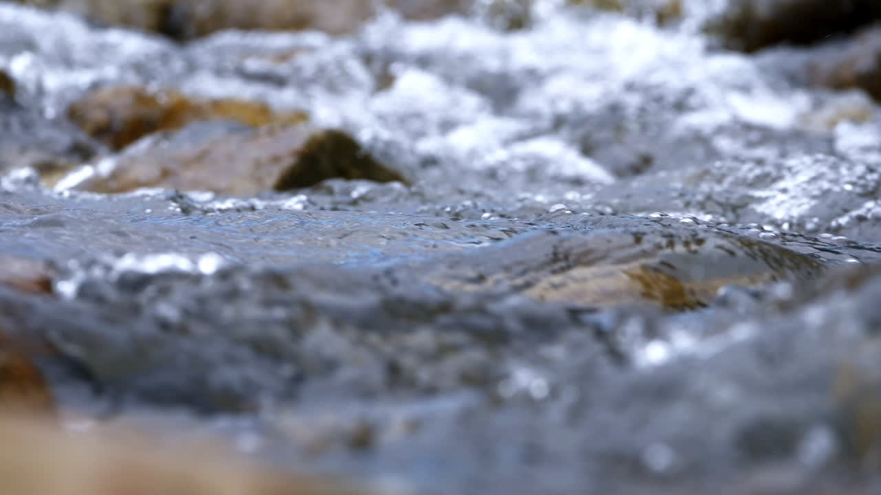 슬로우 모션으로 흐르는 풍부한 강 돌 바위를 통해 흐르는 맑은 스트림