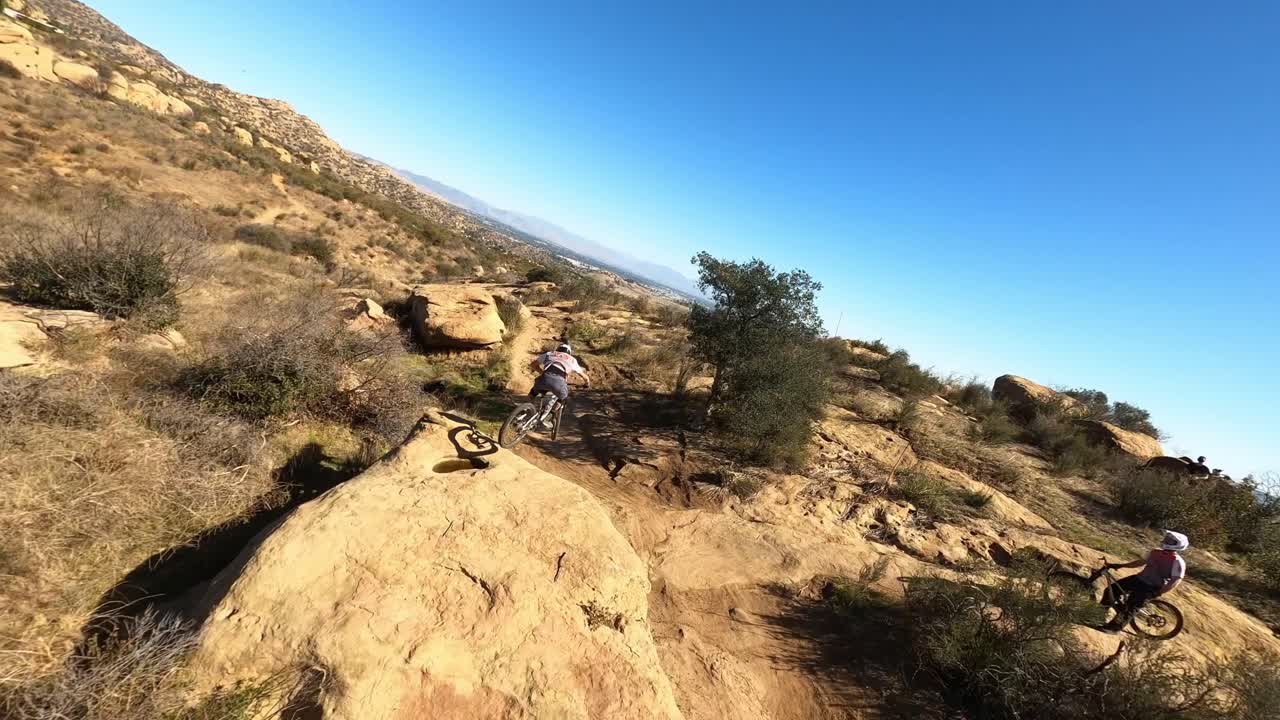 Drone chasing mtb rider off downhill jumps made of dirt