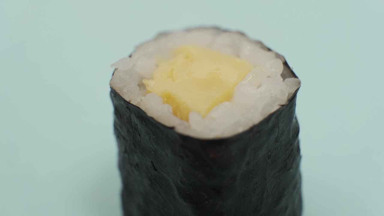 fotografía de estudio de un rollo de sushi sobre un fondo azul