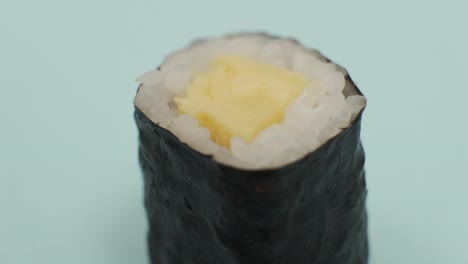 studio shot of sushi roll on blue background