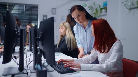 dos mujeres de negocios trabajando en una computadora en una oficina