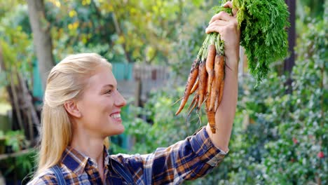 happy gardener holding freshly cultivated carrots