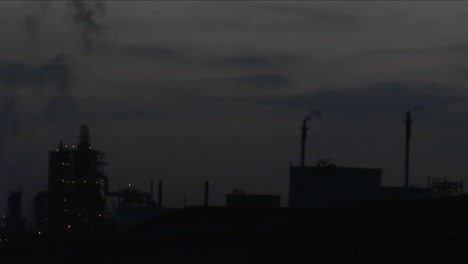 a time lapse shot from night to day of a petrochemical factory or oil refinery