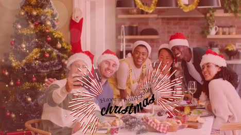 Animation-of-have-a-holly-jolly-christmas-text-over-diverse-friends-sitting-at-table-at-christmas