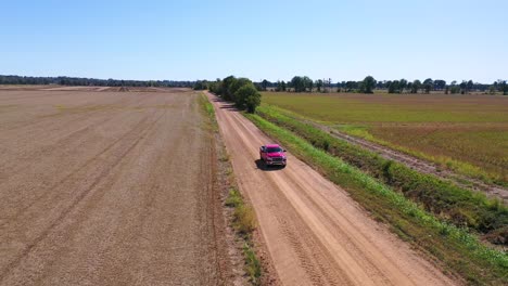 Luftaufnahme-Eines-Roten-Pickups,-Der-Auf-Einer-Unbefestigten-Straße-In-Einem-Ländlichen-Farmgebiet-Von-Mississippi-2-Fährt