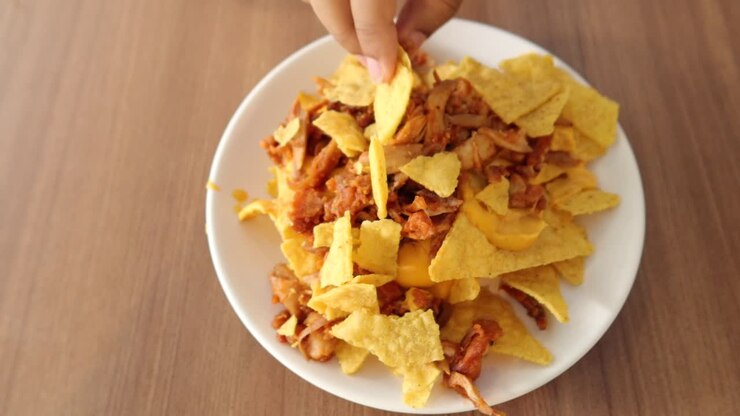 Corn chips nachos with fried meat on table