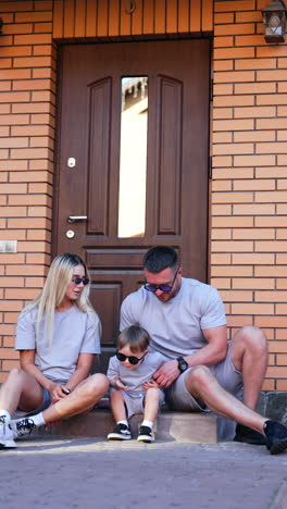 family enjoying a sunny day at home. family relaxes on the front steps of their home while sharing joyful moments and laughter together