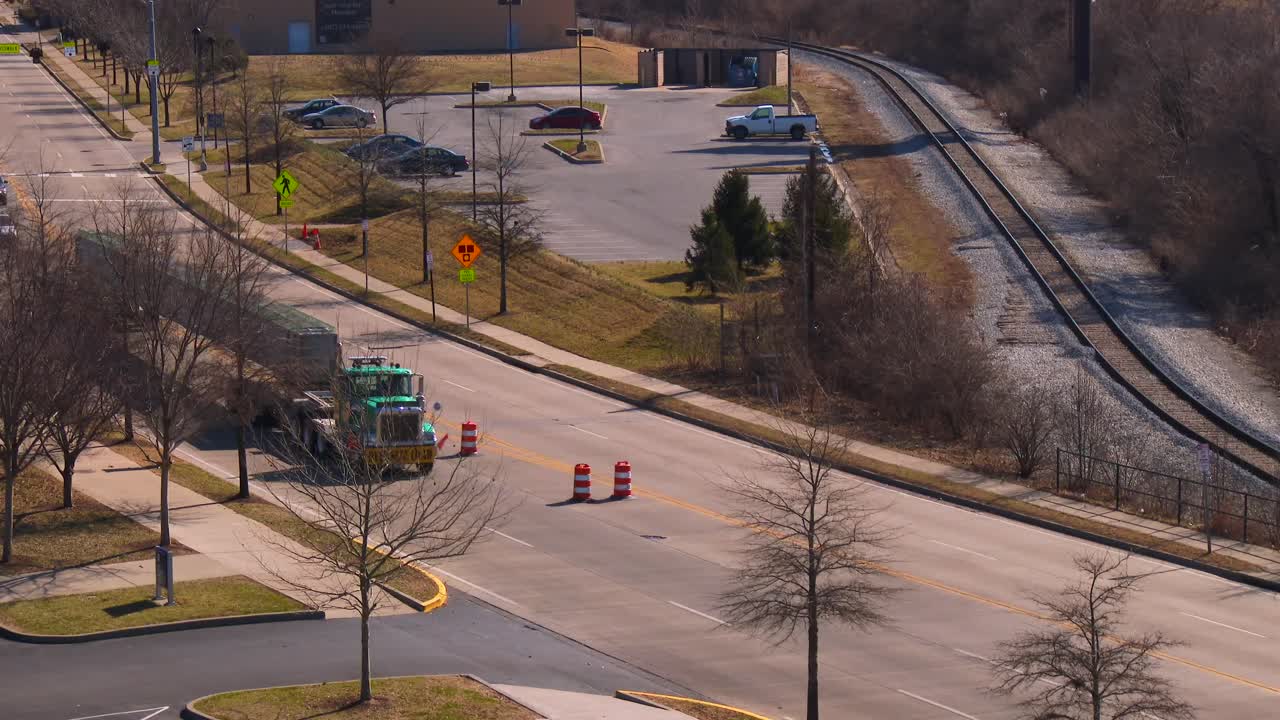 넓은 로드 트럭이 대형 콘크리트 빔을 건설 현장에 전달합니다.