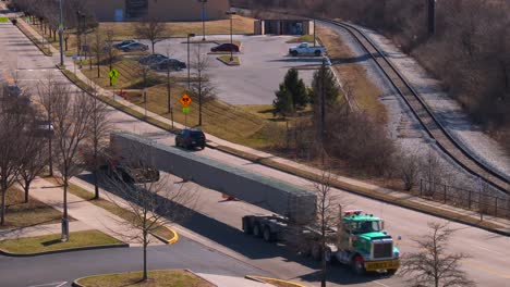 a wide load truck delivers a large concrete beam to a construction site