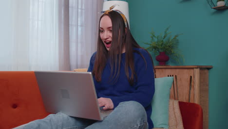mujer adulta joven en la oficina de casa usar computadora portátil computadora mecanografiando navegación decir wow sí descubrió gran gran victoria