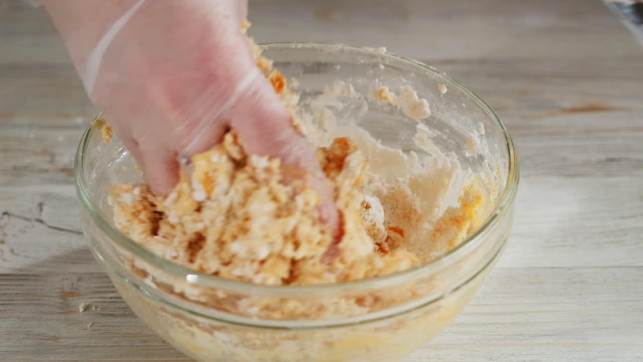 Hand Mixing Dough with Flour and Spices in a Glass Bowl