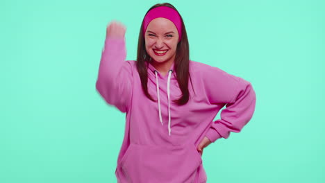 Teen-girl-in-pink-hoodie-shouting,-raising-fists-in-gesture-I-did-it,-celebrating-success,-winning