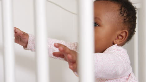 happy baby girl playing in nursery cot shot in slow motion