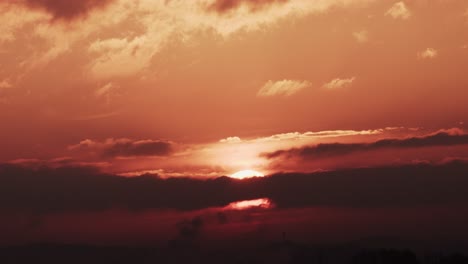 el lapso de tiempo de un amanecer épico que se eleva por encima de las nubes con un resplandor ardiente, un sol rojo ardiente
